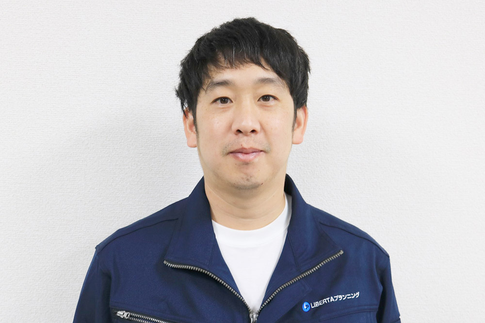 株式会社LIBERTAプランニングの社員の写真。電気設備・機械設備工事の現場で安全に作業を行う技術スタッフ。